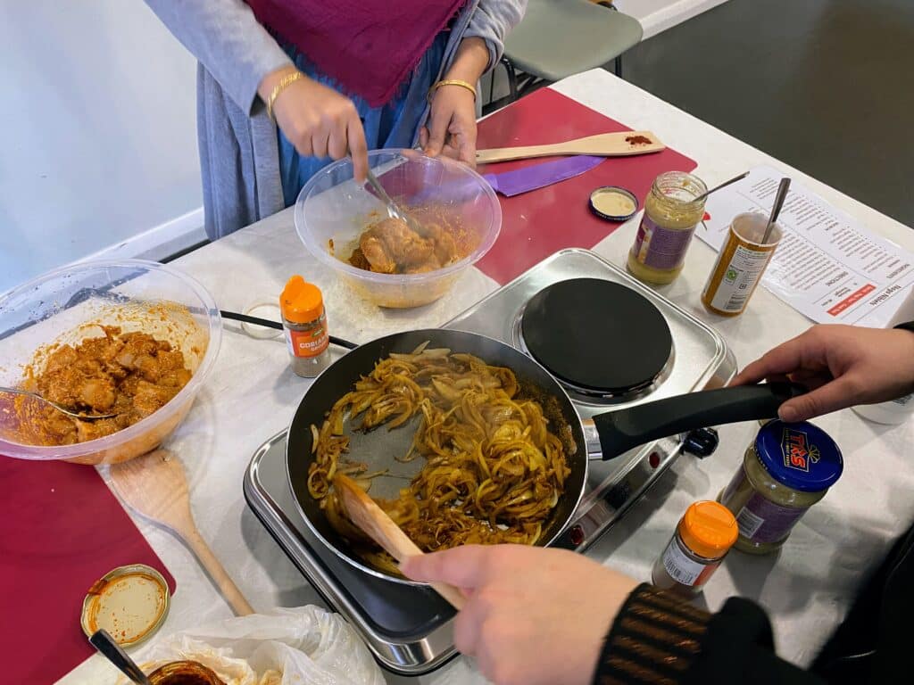 Tower Hamlets residents cooking healthier versions of traditional Bengali recipes, during Well One's 'Cook Well, Eat Well' worskhops.