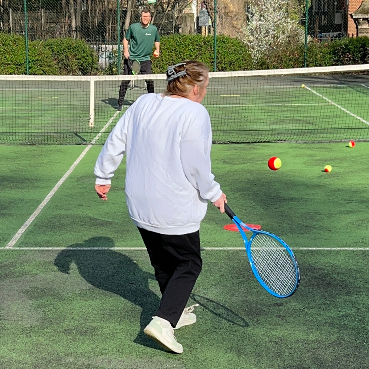 A Poplar resident plays tennis for the first time with Courtside Tower Hamlets coach, Lee.
