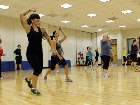 A group of women exercises in a community hall