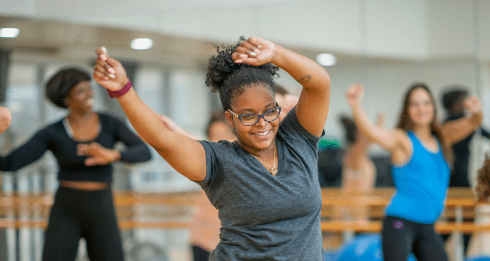 A woman energetically dancing with her arms in the air