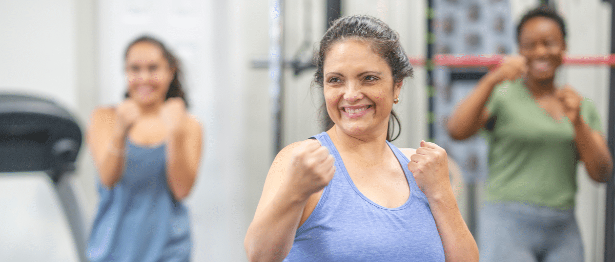 Two women taking part in a Boxercise class at Island House Community Centre, with their fists raised ready to jab