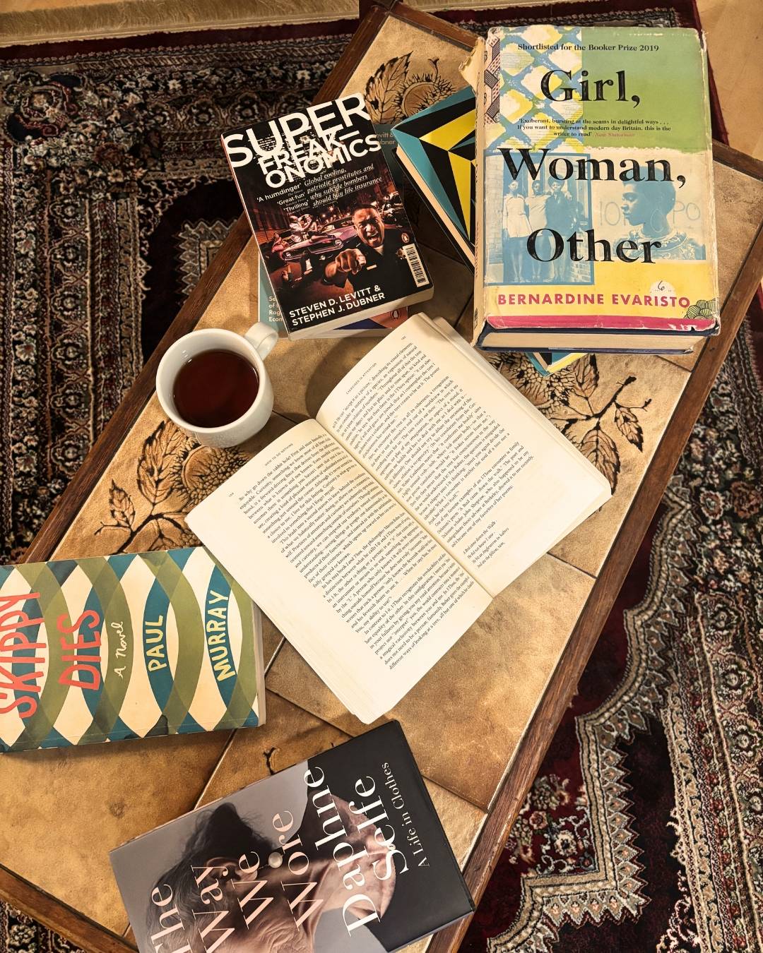A coffee table scattered with books