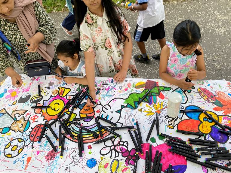 A group of children get creative on a joint colourful drawing